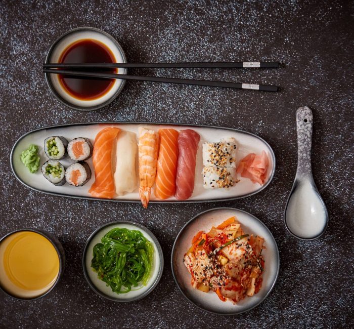 asian-food-assortment-various-sushi-rolls-placed-ceramic-plates-kimchi-goma-wakame-salads-soy-souce-chopsticks-sides-grungy-dark-background-with-copy-space (1)